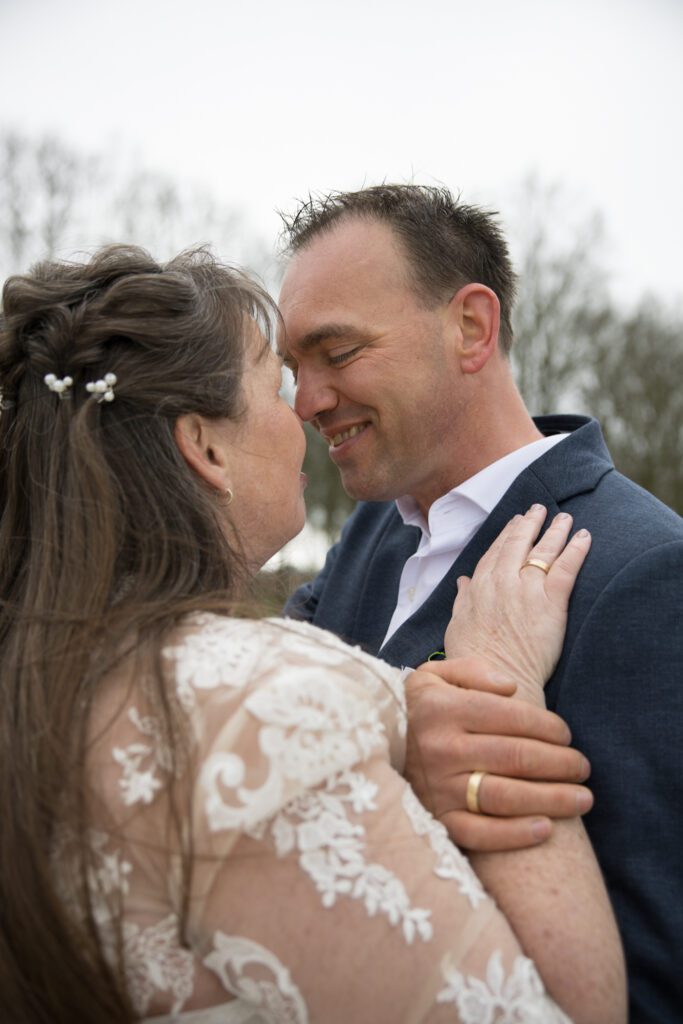 Bruidspaar met liefdevolle blik op strand van Ermelo voor de bruiloft