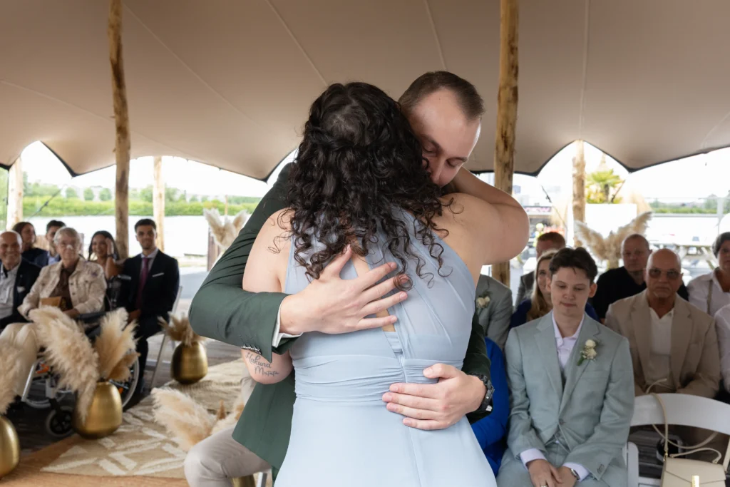 Emotionele trouw foto van omhelzing tussen bruidegom en zijn zus voor de ceremonie van de bruiloft